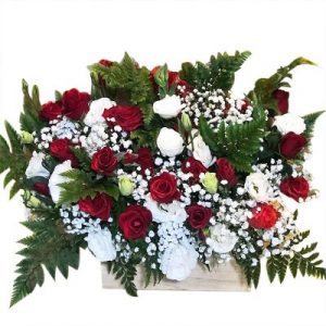 A wooden basket of two dozen assorted roses